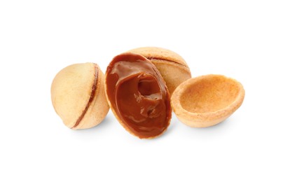 Photo of Delicious nut shaped cookies with boiled condensed milk on white background