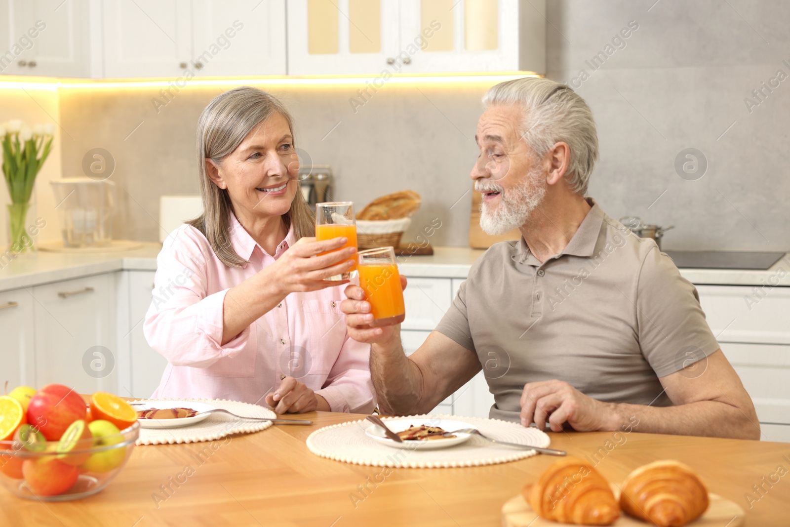 Photo of Happy senior couple having breakfast at home