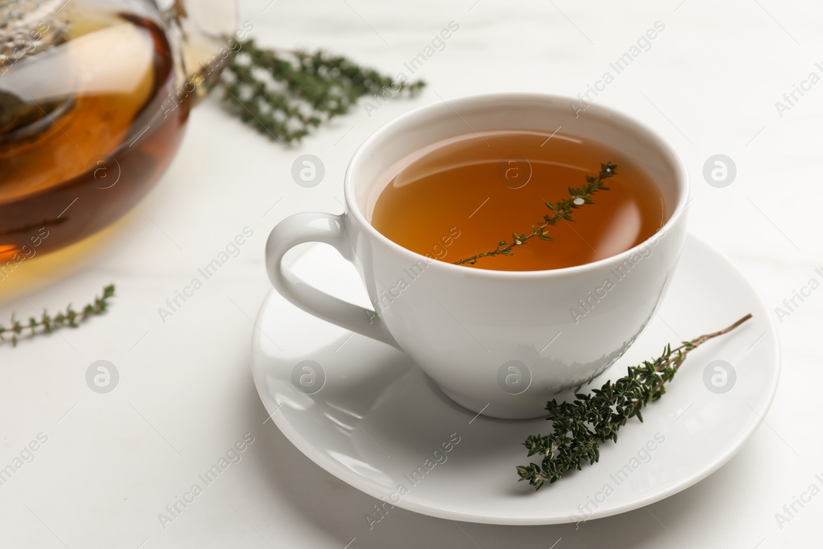 Photo of Aromatic herbal tea with thyme on white marble table