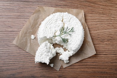 Photo of Delicious cottage cheese with dill on wooden table, top view