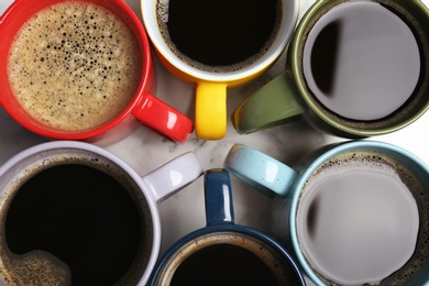 Many cups with tasty aromatic coffee on table, flat lay