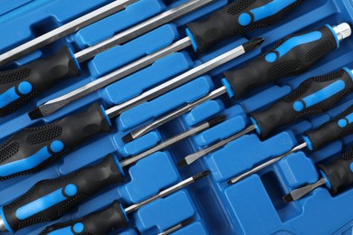 Set of screwdrivers in toolbox as background, top view
