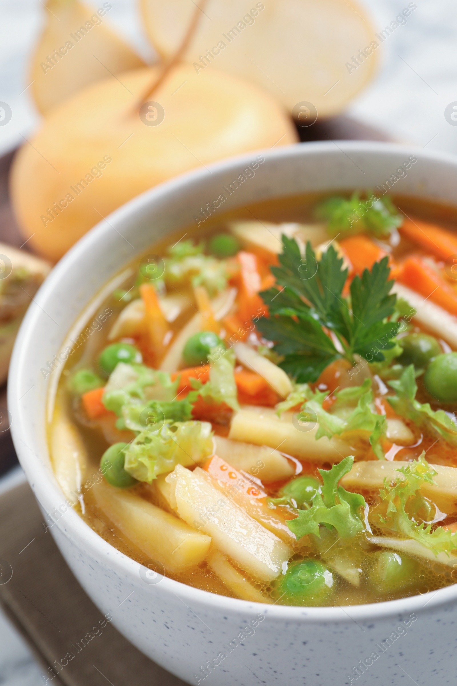 Photo of Bowl of delicious turnip soup on white marble table, closeup