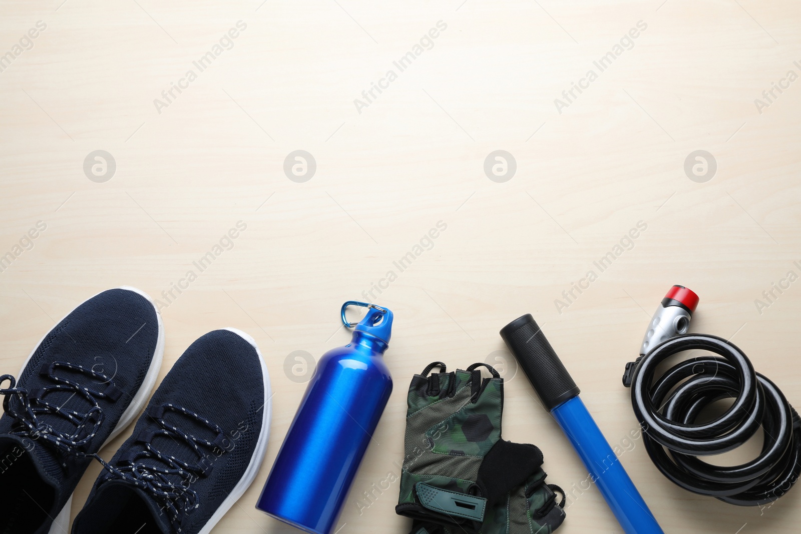 Photo of Flat lay composition with different cycling accessories on wooden background, space for text