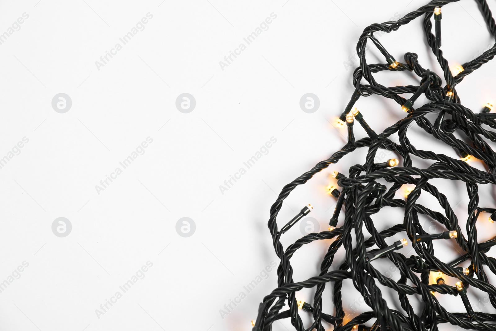 Photo of Beautiful Christmas lights on white background, top view