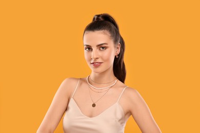 Photo of Beautiful woman with elegant jewelry on orange background