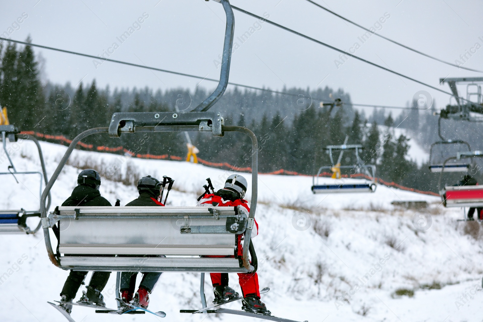 Photo of Chairlift with people at ski resort. Winter vacation