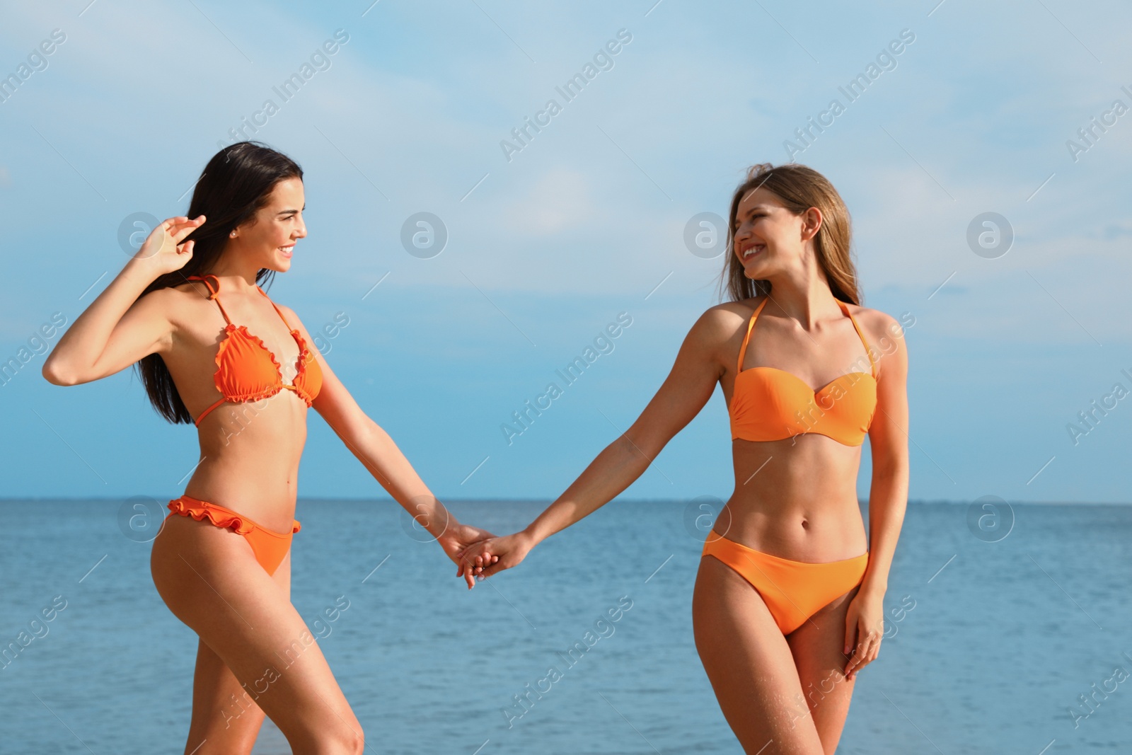 Photo of Young couple in bikini spending time together on beach