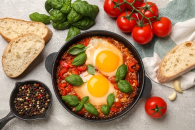 Photo of Delicious Shakshuka served on light grey table, flat lay