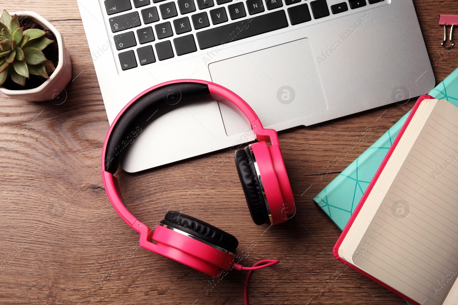 Photo of Flat lay composition with headphones and laptop on wooden table