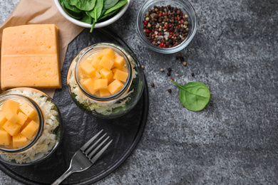 Photo of Healthy salad in glass jars on grey table, flat lay