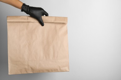 Photo of Woman holding paper bag on white background, closeup. Space for text