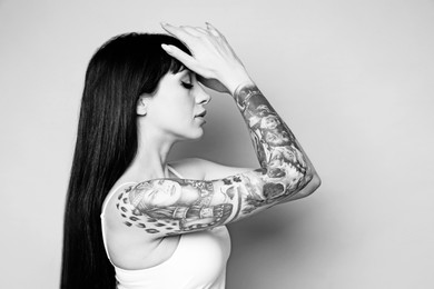 Image of Beautiful woman with tattoos on light background. Black and white photography