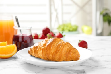 Photo of Tasty breakfast with croissant served on white marble table