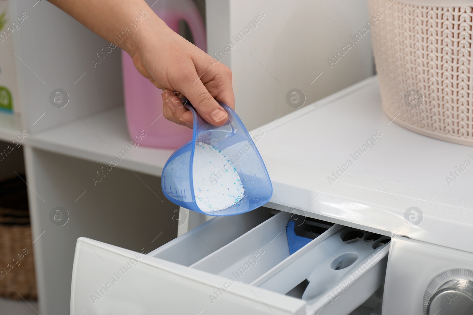 Photo of Woman pouring powder into drawer of washing machine indoors, closeup. Laundry day