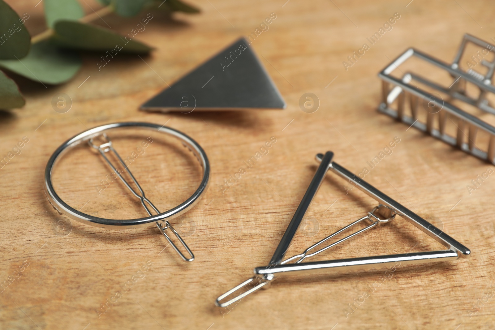 Photo of Stylish silver hair clips on wooden table