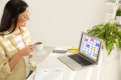 Young woman using calendar app on laptop in office