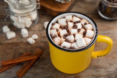 Photo of Cup of chocolate milk with marshmallows on wooden table, closeup