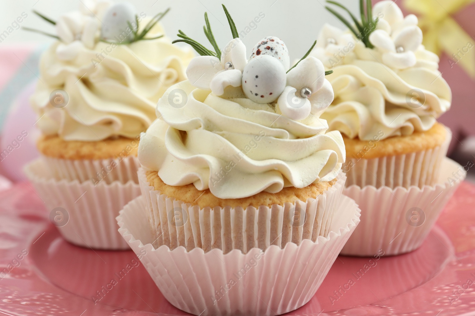 Photo of Tasty Easter cupcakes with vanilla cream on table, closeup