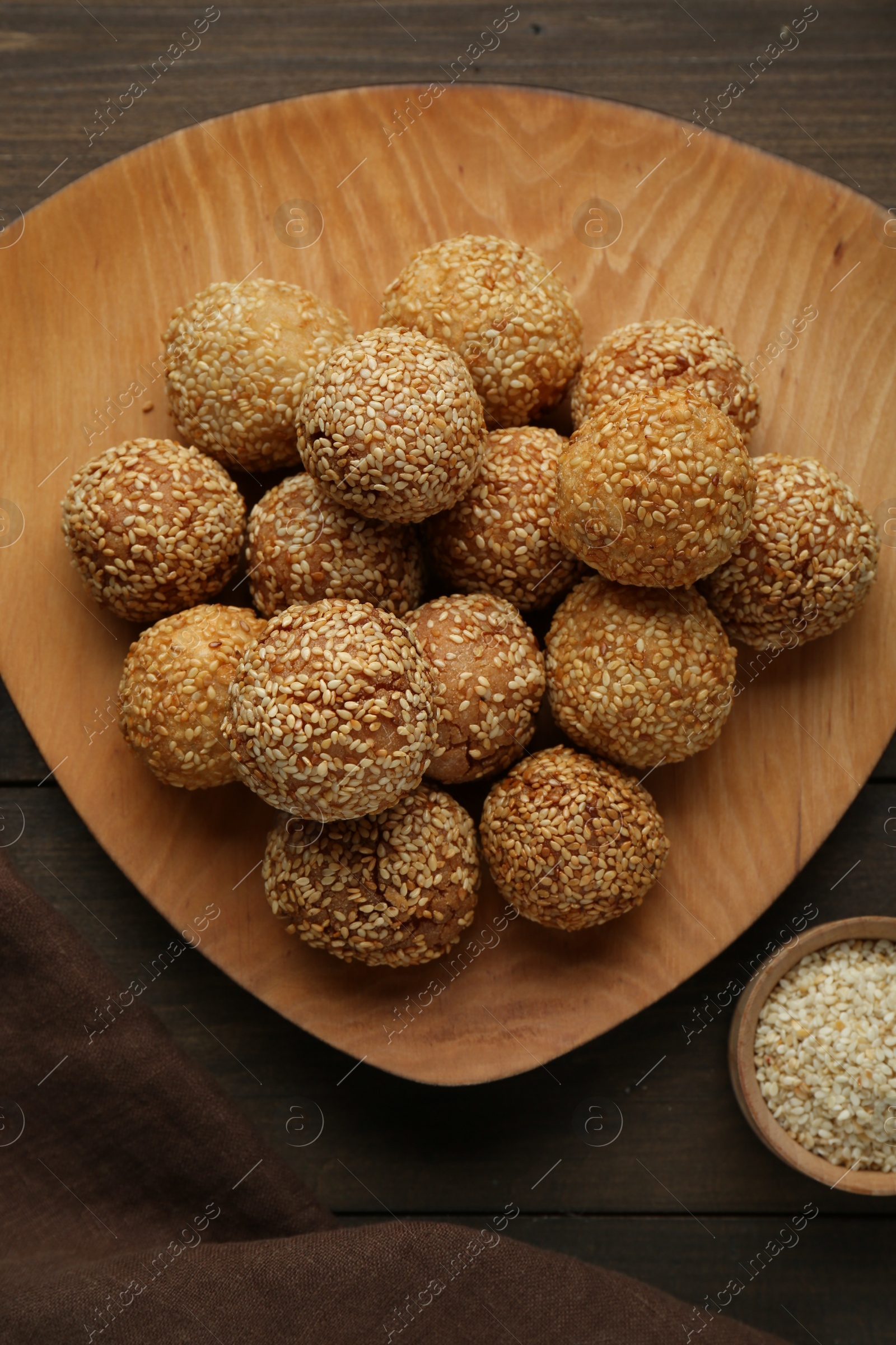 Photo of Delicious sesame balls on wooden table, flat lay
