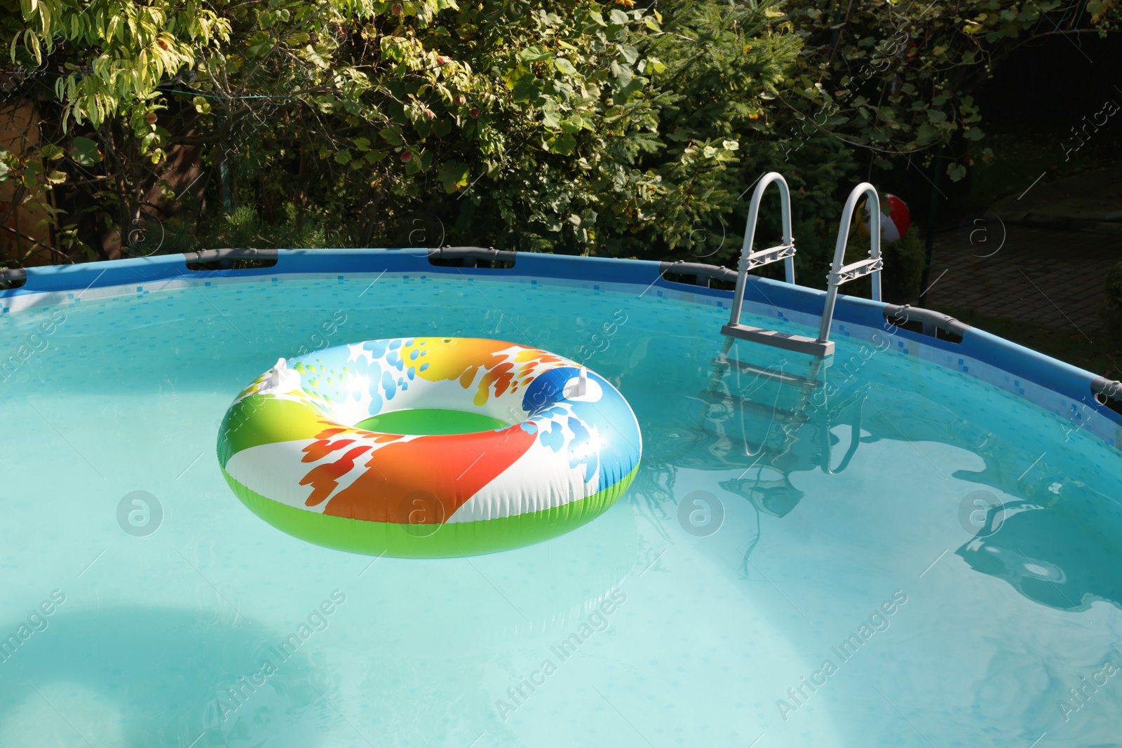 Photo of Inflatable ring floating on water in above ground swimming pool outdoors