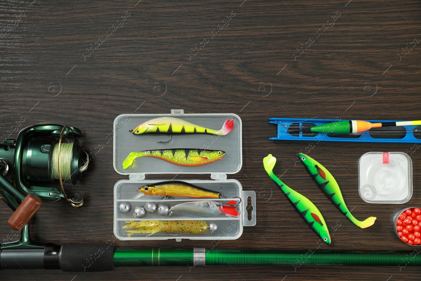 Photo of Fishing tackle on dark wooden background, flat lay. Space for text