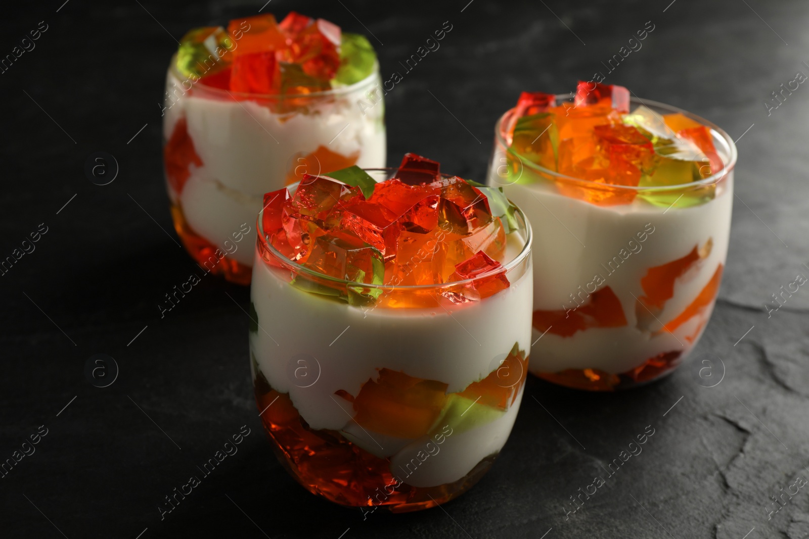 Photo of Delicious broken glass jelly dessert on black table