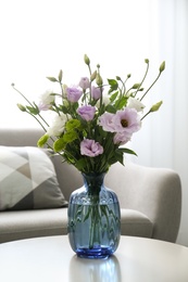Photo of Bouquet of beautiful Eustoma flowers on table in room