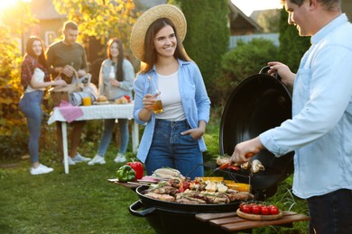 Group of friends having barbecue party outdoors. Space for text