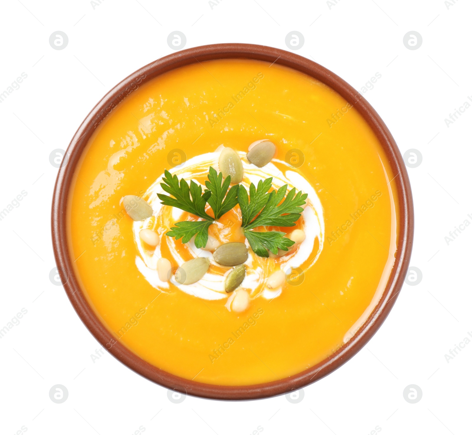 Image of Tasty creamy pumpkin soup in bowl on white background, top view