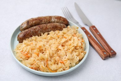 Photo of Plate with sauerkraut and sausages on light table