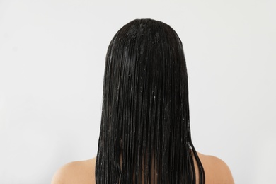 Photo of Woman with mask on her long hair in light bathroom