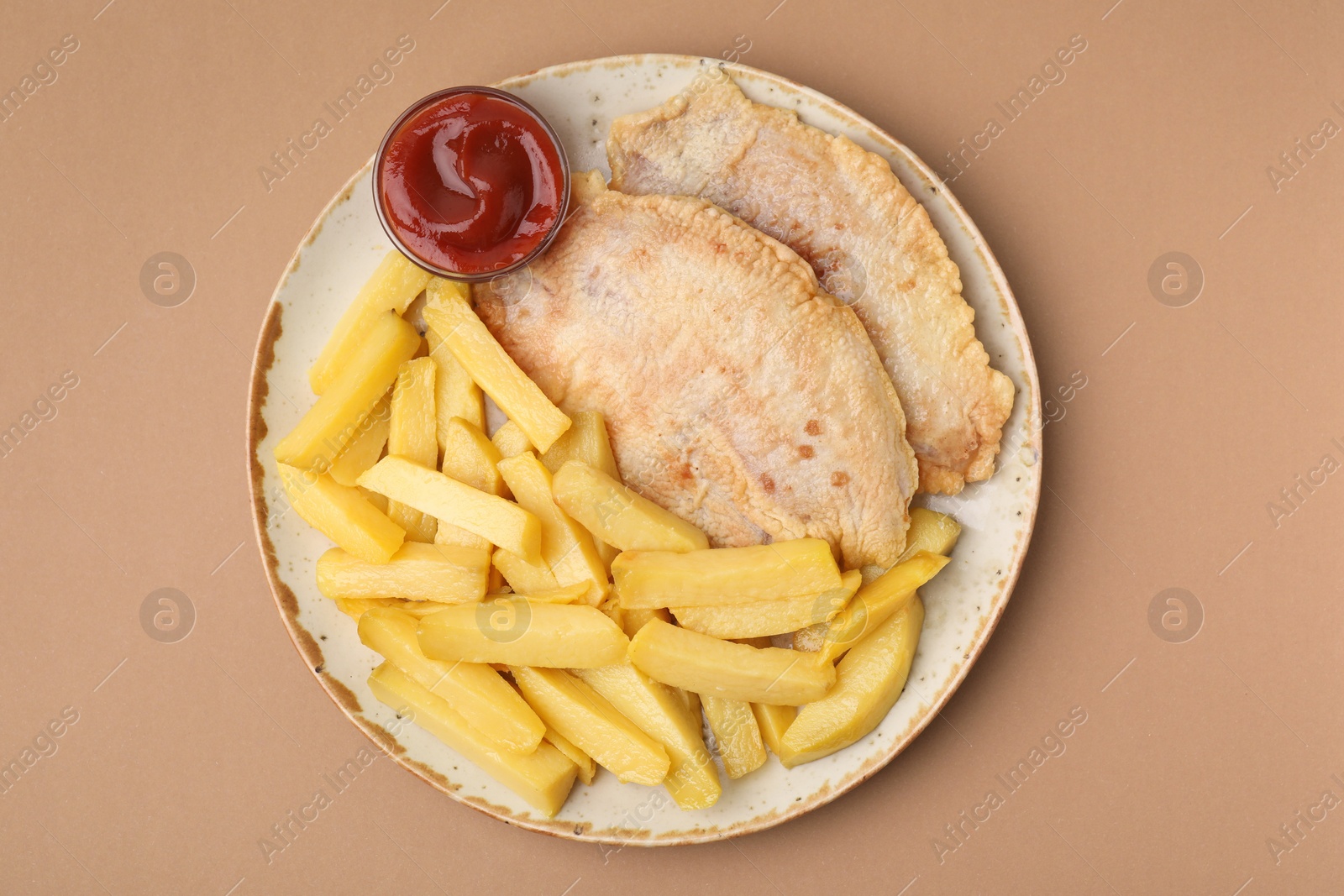 Photo of Delicious fish and chips with ketchup on light brown table, top view