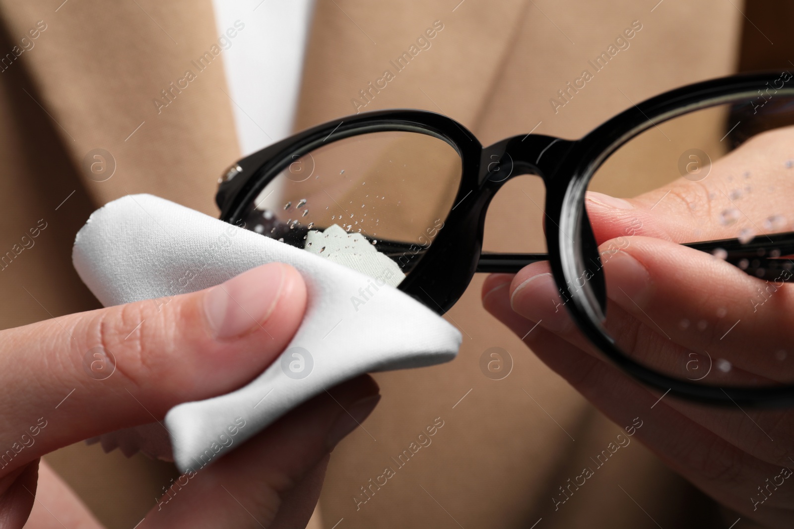 Photo of Woman wiping her glasses with microfiber cloth, closeup