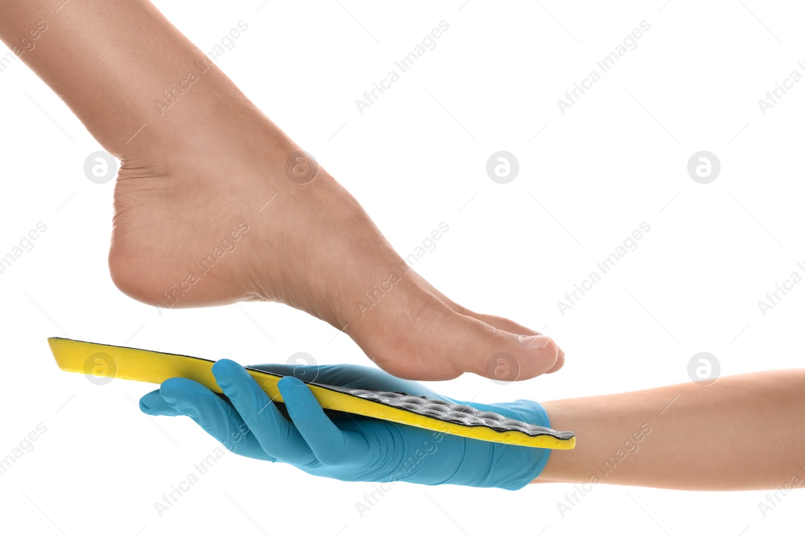 Photo of Orthopedist fitting insole on patient's foot against white background, closeup