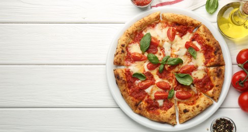 Photo of Delicious Margherita pizza and ingredients on white wooden table, top view. Space for text