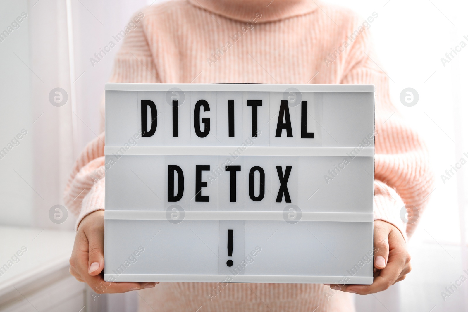 Photo of Woman holding lightbox with phrase DIGITAL DETOX at home, closeup