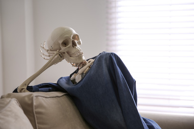 Human skeleton on sofa in living room