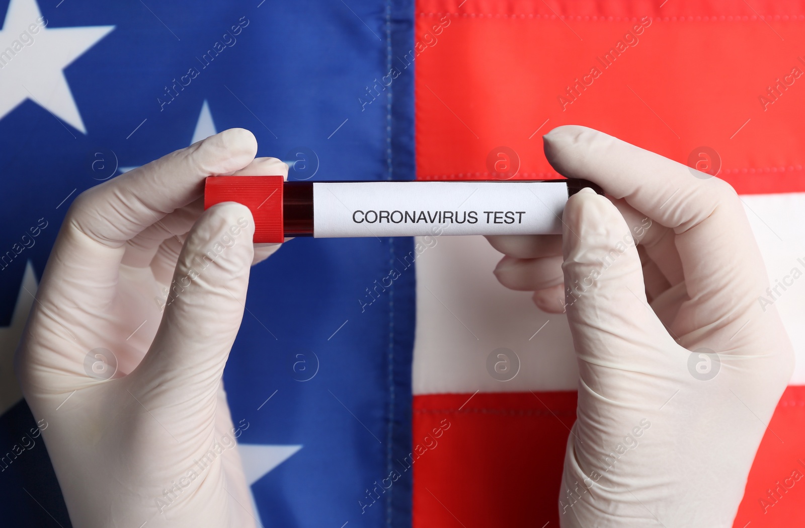 Photo of Scientist holding test tube with blood sample over American flag, closeup. Coronavirus pandemic in USA