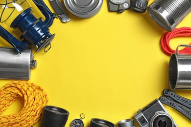 Frame of traveler's equipment on yellow background, flat lay. Space for text