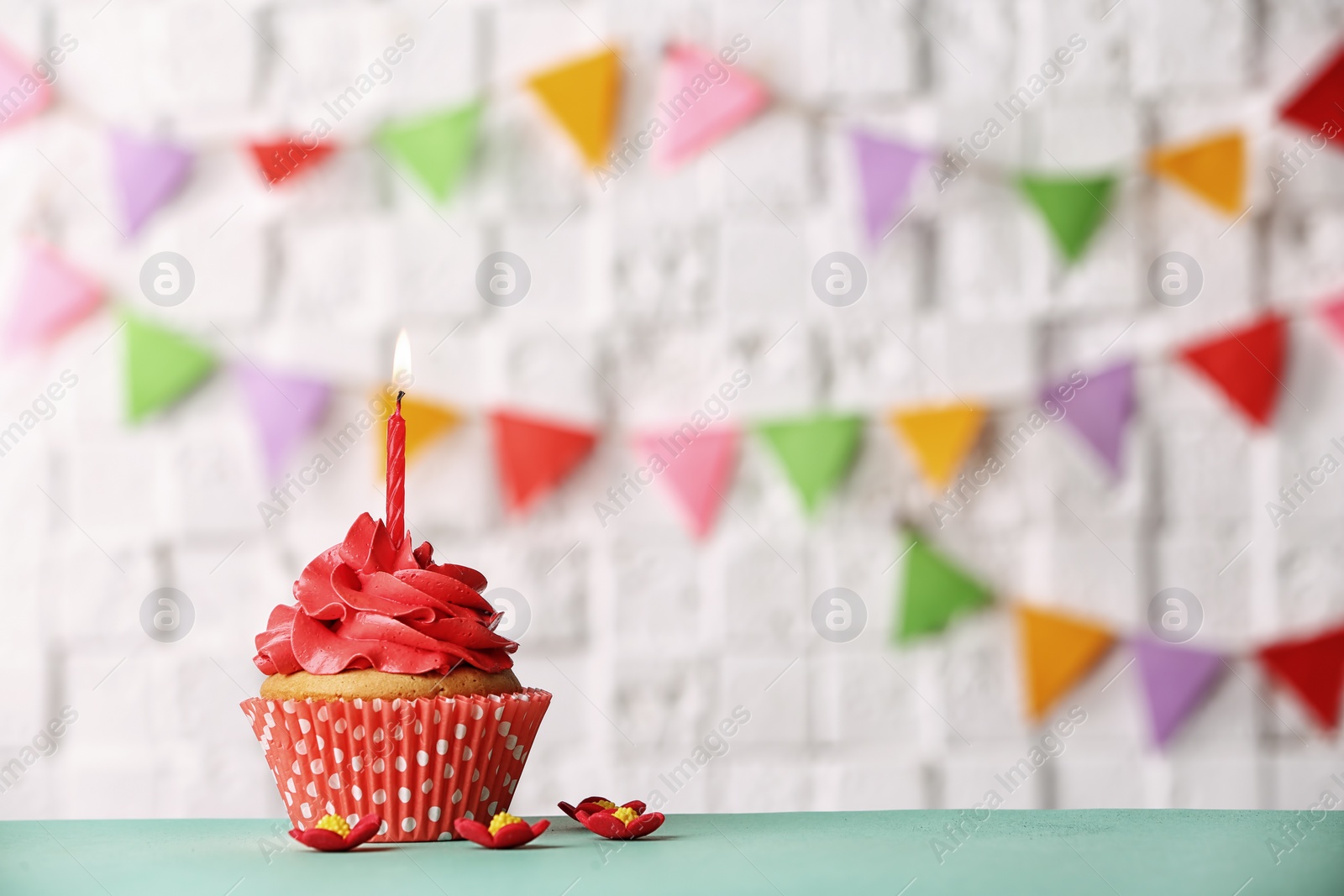 Photo of Birthday cupcake with candle against blurred background