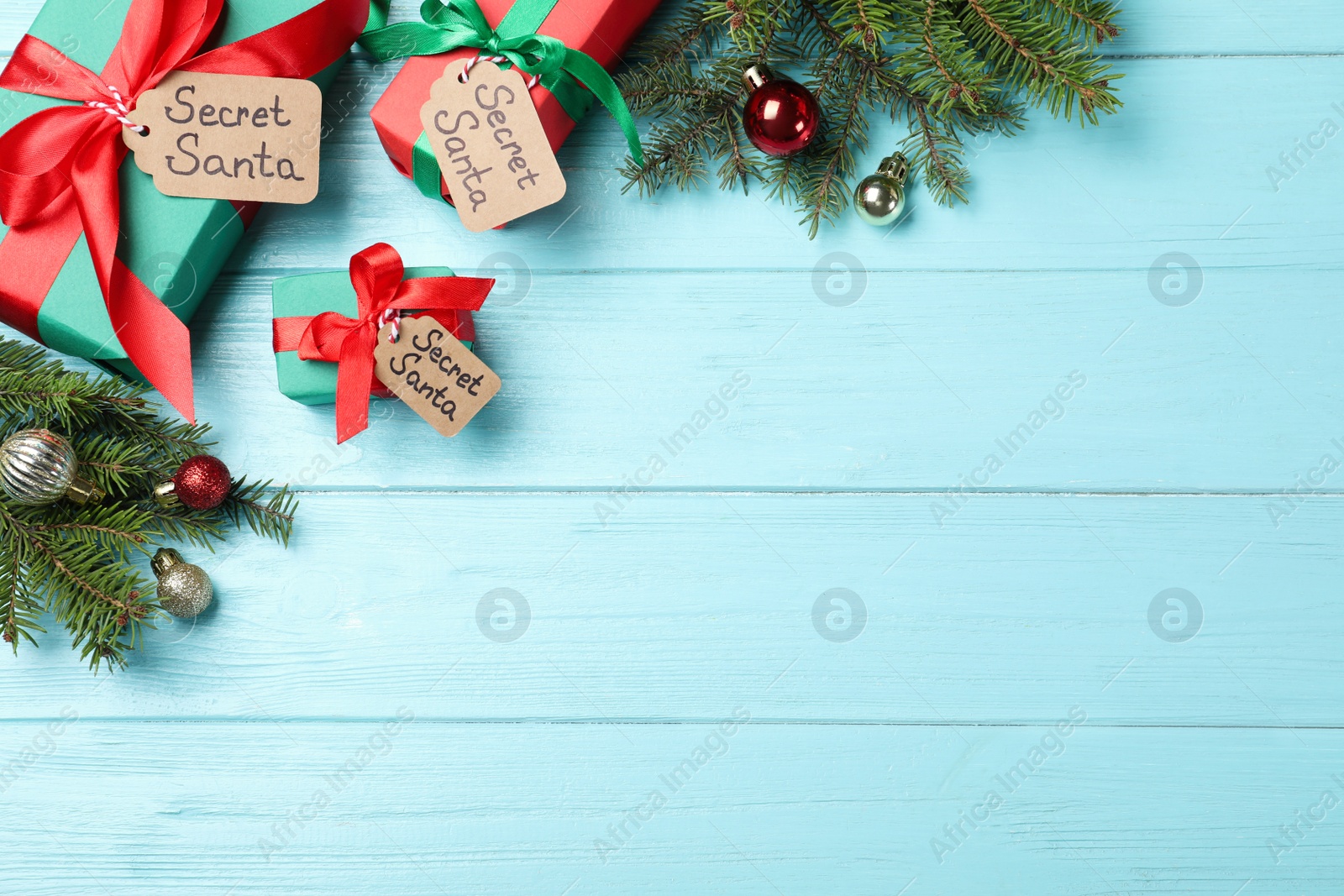 Photo of Flat lay composition with presents from secret Santa on turquoise wooden table, space for text