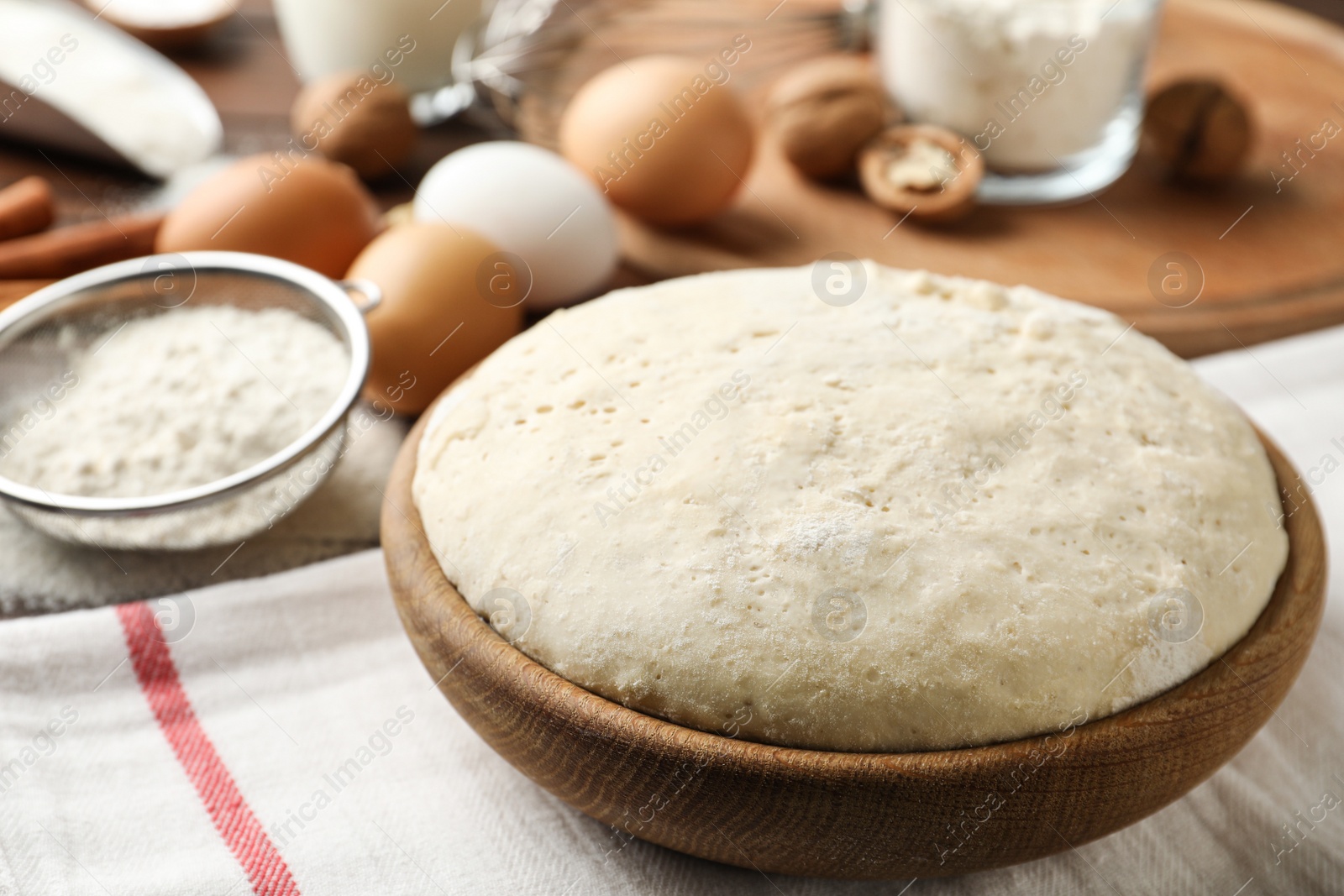 Photo of Bowl with dough for pastries on table, closeup