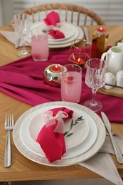 Photo of Color accent table setting. Plates with pink napkins, glasses and cutlery, closeup