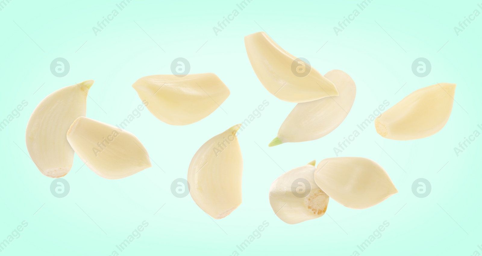 Image of Fresh garlic cloves falling on aquamarine background, banner design