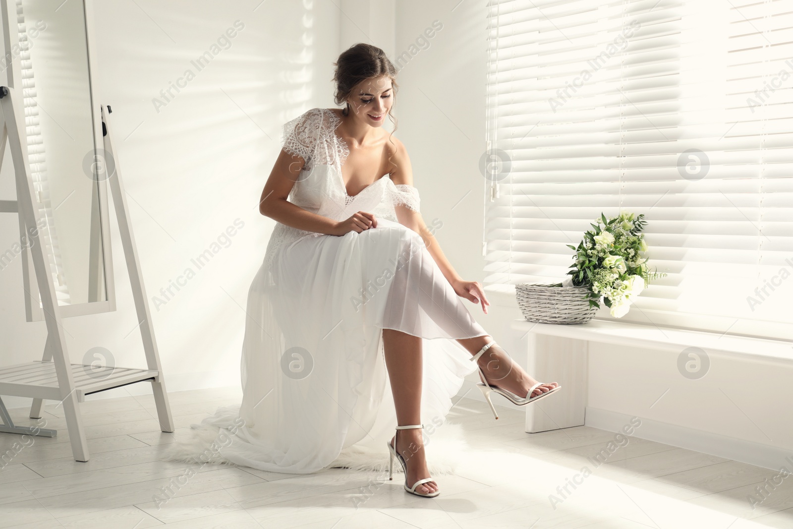 Photo of Young bride wearing beautiful wedding dress in room