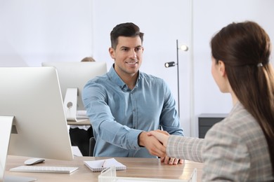 Photo of Employee shaking hands with intern in office