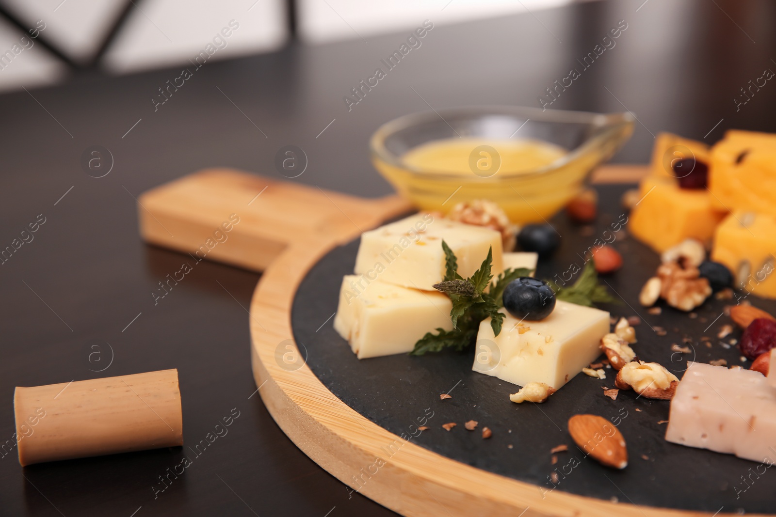 Photo of Different types of delicious cheeses, berries and nuts on table, closeup