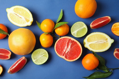 Different citrus fruits on color background, top view