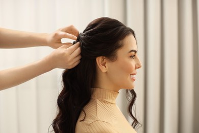 Photo of Hair styling. Professional hairdresser working with smiling client indoors, closeup